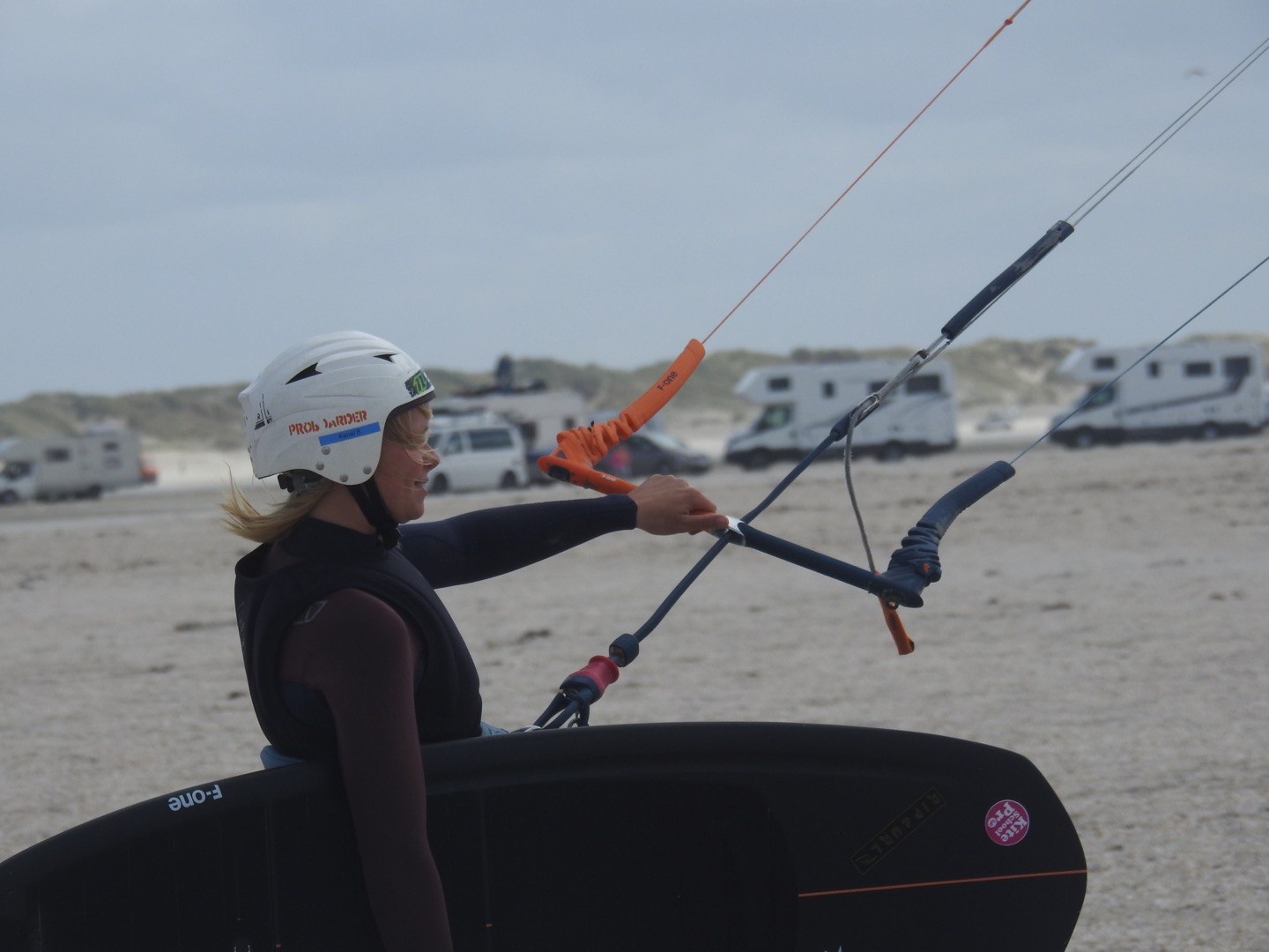 Kitesurferin mit Board und Steuerbar am Strand von Sylt